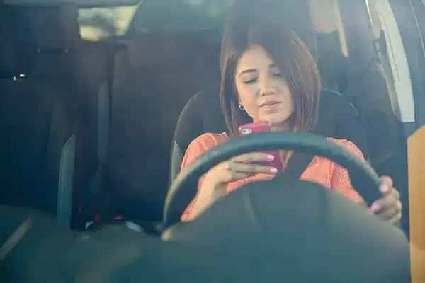 Young person texting and driving.