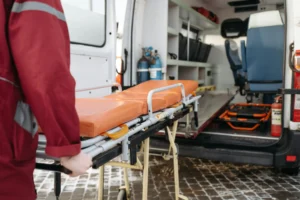 Someone rolling a stretcher out of an ambulance truck.