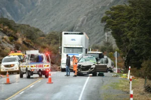 A truck accident scene with multiple damaged cars and a fire truck.