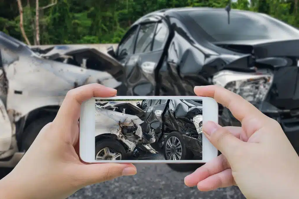Someone taking a picture of a car accident scene.