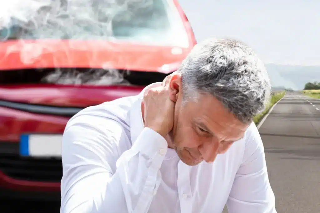 An injured man holding his neck after a crash, representing the aftermath of a car accident case that may take time to settle in Houston.
